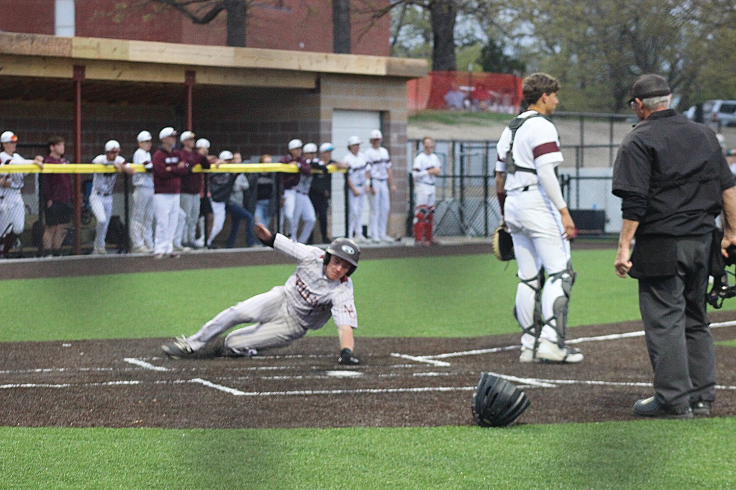 Mountain Grove’s Gatlin Keeling slides with his hand stretched out to touch home plate for a big run against Logan-Rogersville.
